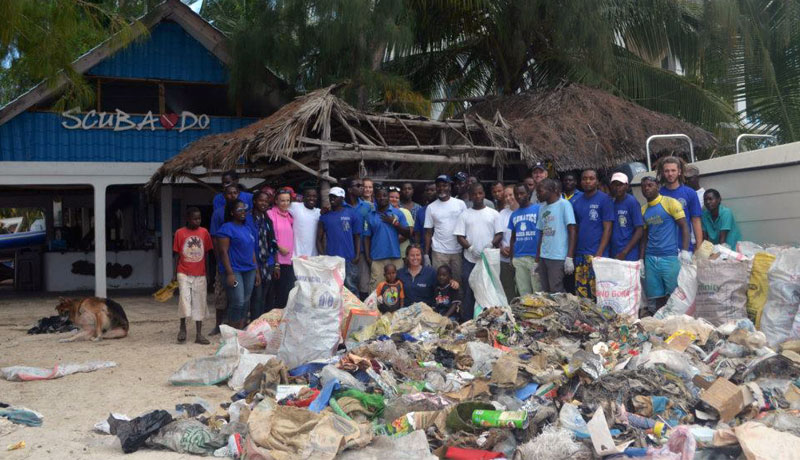 Beach cleanup volunteers standing behind the rubbish collected